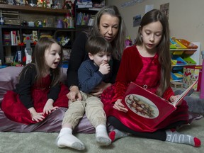Megan Lucas's daughter Amelia reads a christmas story to twins Isabella and Isaac in the family home, Delta,  December 14 2018.