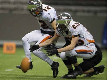 VANCOUVER December 01 2018.   New Westminster Hyacks #12 Greyson Planinsic watches as #25 Shaye Rathjen recovers a fumbled Mount Douglas Rams football in the AAA final of the BC high school football championships at the Subway Bowl 2018, BC Place, Vancouver,  December 01 2018.   Gerry Kahrmann  /  PNG staff photo) 00055454B [PNG Merlin Archive]