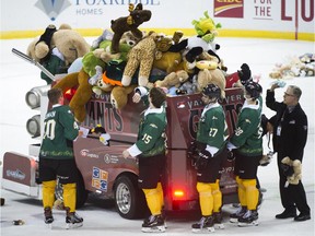 Vancouver Giants players load teddy bears that were thrown on the ice during the team's annual Teddy Bear Toss on Saturday at Pacific Coliseum.