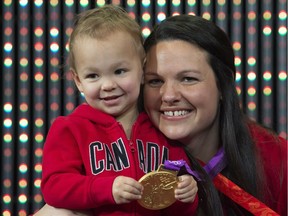 Canadian weightlifter Christine Girard poses with her daughter Aliana as she holds the gold medal presented during a ceremony Dec. 3 in Ottawa. Girard was awarded the 2012 London gold and 2008 Beijing bronze medals after the IOC disqualified athletes from the 2008 and 2012 Olympics.