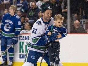 Sam Gagner has his son Cooper shoot for him while competing in the shootout competition during the Canucks Super Skills Contest at Rogers Arena, Dec. 2.