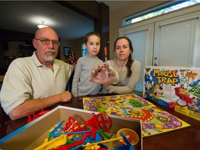 Mitch and Paula Selman and six-year-old son Angus with the Mouse Trap game and syringe they found inside the box at their home in Pitt Meadows.