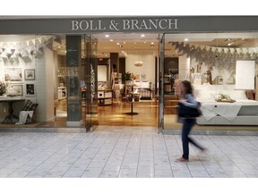 In this Nov. 2, 2018 photo, a patron at the Mall at Short Hills in Short Hills, N.J., passes the Boll & Branch furniture store. At the upscale mall such digital natives as Untuckit, Casper, Boll & Branch and Indochino are becoming destinations for shoppers and are helping to drive more sales and traffic, says Jamie Cox, mall manager. The online retailers are an integral part of the mall's overall strategy to recruit retailers that offer special shopping experiences.