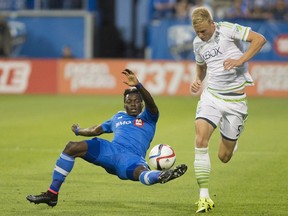 File: Montreal Impact's Ambroise Oyongo, left, challenges Seattle Sounders' Andy Rose during first half MLS soccer action in Montreal, Saturday, July 25, 2015. Andy Rose has has agreed to a Major League Soccer contract with the Vancouver Whitecaps through 2020 and the club will have an option to extend through 2021.