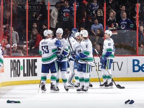 Elias Pettersson celebrates his overtime goal and hat trick against the Ottawa Senators with teammates.