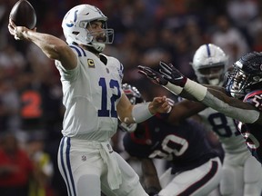 Andrew Luck of the Indianapolis Colts throws a pass under pressure by Benardrick McKinney of the Houston Texans in the first quarter during the Colts' 21-7 wild card win at NRG Stadium in Houston on Saturday.