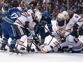 Goalie Mikko Koskinen of the Edmonton Oilers reaches to try and cover up the puck.