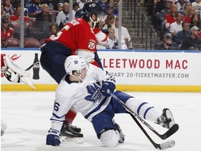 Aaron Ekblad of the Florida Panthers takes Mitch Marner of the Toronto Maple Leafs to the ice in front of the net at the AT&T Center on January 18, 2019 in Sunrise, Florida.