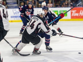Jadon Joseph battles a Lethbridge Hurricanes checker on Friday in Lethbridge. It was Joseph's first game with the Vancouver Giants after a trade with the Regina Pats.