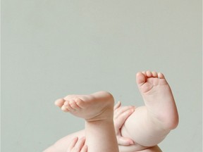Baby lying on back with hands and feet in the air. stock image. Getty Images/iStock Photo
