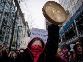 Tilly Innes of the St'at'imc Nation raises a drum in the air and cheers during a march in support of pipeline protesters in northwestern B.C. in Vancouver on Jan. 8.