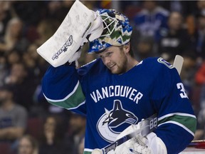 Vancouver Canucks goalie goalie Thatcher Demko adjusts his mask during a break in play against the Buffalo Sabres  in the second period of a regular season NHL hockey game at Rogers Arena on Jan. 18.