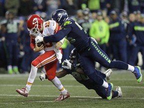 Kansas City Chiefs quarterback Patrick Mahomes (15) is tackled by Seattle Seahawks defensive end Frank Clark, right, during the second half of an NFL football game, Sunday, Dec. 23, 2018, in Seattle. The Seahawks won 38-31.