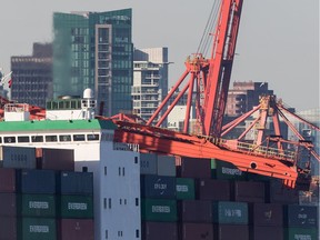 A large crane that collapsed rests on top of cargo containers on a freighter at Port Metro Vancouver's Vanterm facility, in Vancouver, on Monday January 28, 2019. A spokeswoman for Global Container Terminals Vanterm says the ship was coming in to berth early Monday morning when it made contact with a ship-to-shore crane on the dock, shutting down operations at one dock of the busy port.