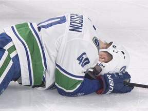 Vancouver Canucks' Elias Pettersson lies injured on the ice after Montreal Canadiens' Jesperi Kotkaniemi, not shown, took him down from behind Thursday.