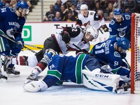 Vancouver Canucks' Troy Stecher (51) prevents Laurent Dauphin (12) from scoring as Vancouver Canucks goalie Jacob Markstrom (25), sprawls across the ice during the third period of an NHL hockey game in Vancouver, on Thursday January 10, 2019.