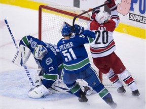 Troy Stecher keeps Hurricanes centre Sebastian Aho from getting a shot past Jacob Markstrom.