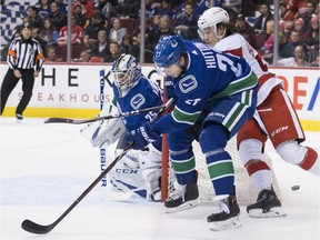 Vancouver Canucks defenceman Ben Hutton (27) fights for control of the puck with Detroit Red Wings left wing Tyler Bertuzzi (59) during first period NHL action in Vancouver, Sunday, Jan 20, 2019.