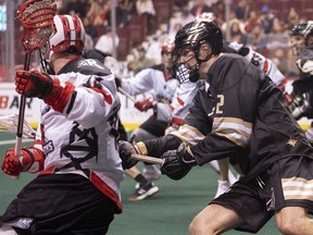Vancouver Warriors Matt Beers (right) tries to check Calgary Roughnecks Dane Dobbie during NLL lacrosse action earlier this season.