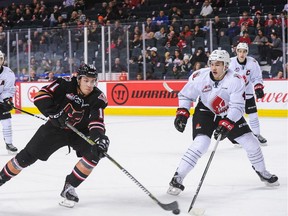 Moose Jaw Warriors defenceman — and Canucks draftee — Jett Woo (right, moving in against puck-carrying forward Cael Zimmerman of the Calgary Hitmen during a WHL game last month) makes his only visit to the Langley Events Centre on Saturday to take on the Vancouver Giants. (Photo: Derek Leung, Getty Images files)