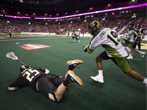 Vancouver Warriors forward Dan Lomas hits the turf as Saskatchewan Rush defender Jordi-Jones Smith chases a loose ball in a regular season NLL lacrosse game at Rogers Arena Saturday.