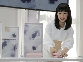 Japanese organizational expert Marie Kondo folds an item of clothing as she introduces her new line of storage boxes during a media event in New York on July 11, 2018. A decluttering craze fuelled by Marie Kondo's new Netflix show is sparking joy for adherents, but also highlighting the hurdles and unspoken practices of what it takes to live with less.