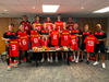 The Canada Rugby Sevens teams poses with the oranged laced shoes in support of Paisley MacRury who is currently battling Leukaemia.