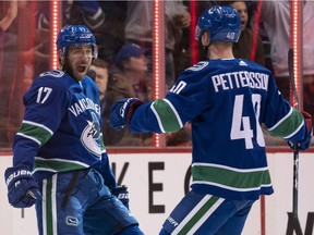 Josh Leivo of the Vancouver Canucks celebrates with teammate Elias Pettersson after scoring a goal against the Calgary Flames on Feb. 9 at Rogers Arena.