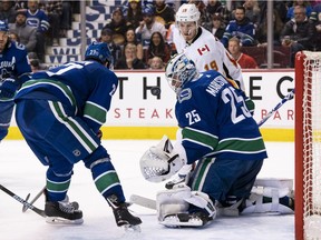 Vancouver goalie Jacob Markstrom watches the puck bounce off his body after making a save against the Calgary Flames last Saturday. He missed the Canucks' last game with reported back spasms.