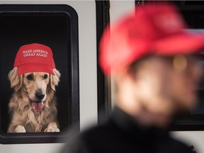 FILE PHOTO: A man stands near a Donald Trump campaign vehicle with an image of a dog in a window before a campaign rally February 5, 2016 in Florence, South Carolina.