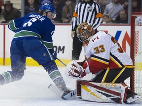 Vancouver Canucks forward Brock Boeser looks back as Calgary Flames goalie David Rittich stops his shot in the first period.