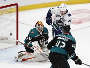 Anaheim Ducks goaltender Kevin Boyle, left, deflects the puck as teammate Josh Manson and Vancouver Canucks' Bo Horvat watch during the third period of an NHL hockey game Wednesday, Feb. 13, 2019, in Anaheim, Calif. The Ducks won 1-0.