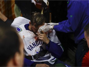 Alex Edler is helped off the ice after suffering a third-period injury.