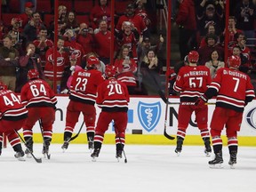 Carolina Hurricanes players skate toward the crowd during an on-ice celebration following their 2-1 win over the New Jersey Devils in an NHL game on Sunday, Nov. 18, 2018, in Raleigh, N.C.