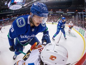 Ashton Sautner, back, checks Calgary Flames forward Dillon Dube into the boards during the first period of a pre-season NHL game in September 2018.