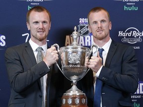 Henrik (left) and Daniel Sedin pose with the King Clancy Memorial Trophy after winning the award for best displaying leadership qualities on and off the ice at the annual NHL awards on June 20, 2018, in Las Vegas.