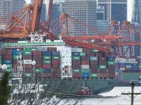 A tug holds the container ship Ever Summit up agains the dock after a crane collapsed and rests on top of a stack of containers while docked at Global Container Terminal in Vancouver, BC, January, 28, 2019.