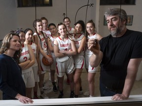 Lord Byng Grey Ghosts senior girls basketball coaches Jennifer Mackay (front left) and Chris Bromige (right) draw up a play for their team, which is headed to B.C. Triple A girls basketball championship at Langley Events Centre.
