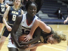 Deja Lee of the Semiahmoo Totems, left, battles for ball possession Thursday with Lily Pink of the Okanagan Mission Huskies during the triple-A girls' provincial basketball championship at the Langley Events Centre.