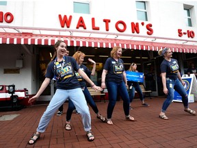 Walmart associates dance in front of Sam Walton's original 5 & 10 store, now a museum, during the annual shareholders meeting event on May 31, 2018 in Bentonville, Arkansas.