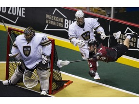 Colorado Mammoth Ryan Lee is sent flying around Vancouver Warrior defender Tyler Codron as he tries to get a shot on Vancouver goalie Eric Penny during NLL action at Rogers Arena on Jan. 26.