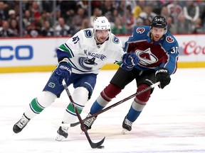 Sven Baertschi of the Vancouver Canucks brings the puck down the ice against J.T. Compher of the Colorado Avalanche during NHL action in Denver on Feb. 2.