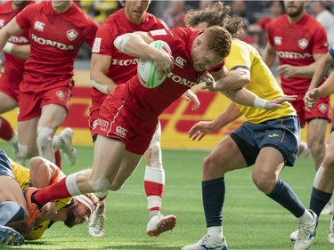 Connor Braid of Canada tries to fight through the tackle of two Spain defenders during rugby sevens action on Day 2 of the HSBC Canada Sevens at BC Place on Sunday, March 10, 2019 in Vancouver.