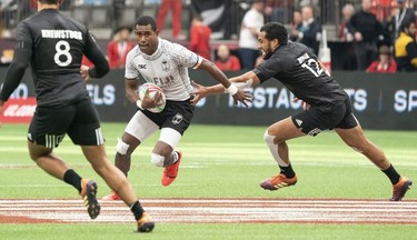Aminiasi Tuimaba of Fiji runs through the defence of Andrew Knewstubb and Sione Molia of New Zealand during rugby sevens action on Day 2 of the HSBC Canada Sevens at BC Place on Sunday, March 10, 2019 in Vancouver.