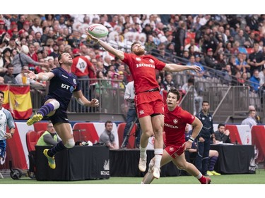 Jake Thiel of Canada (in red) and Charlie Shiel of Scotland battle for the ball during rugby sevens action on Day 2 of the HSBC Canada Sevens at BC Place on Sunday, March 10, 2019.