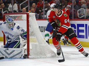 David Kampf of the Chicago Blackhawks tries to get off a shot against Thatcher Demko.