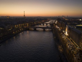 The city of Paris, on the River Seine, at sunset.