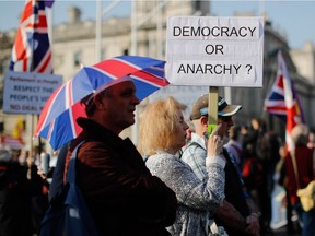 A pro-Brexit demonstrator holds a placard as he gathers with others outside the House of Commons in central London on March 29, 2019 after MPs rejected the EU Withdrawl Agreement for a third time.