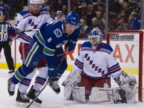 Kevin Shattenkirk clears Brock Boeser from the front of the net.