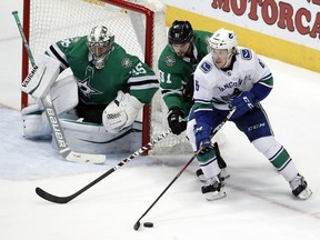 Dallas Stars goaltender Anton Khudobin (35) and Tyler Seguin (91) defend the net against pressure from Vancouver Canucks right wing Brock Boeser (6) during the third period of an NHL hockey game in Dallas, Sunday, March 17, 2019.